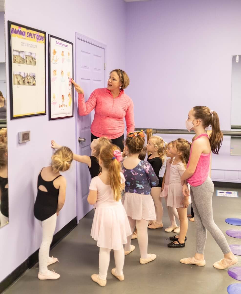 A preschool-age dancer in class looking toward the camera